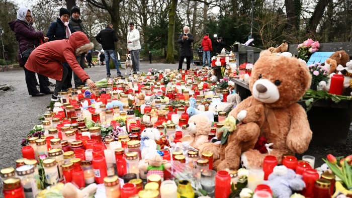People pay their respect and lay candles at a makeshift memorial of candles flowers and soft toys for the victims of a knife attack, on January 24, 2025 in Aschaffenburg,