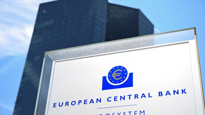 A close-up of the European Central Bank sign with the ECB headquarters building in the background in Frankfurt, Germany.