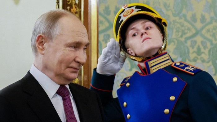 Russia’s President Vladimir Putin walks past a guard