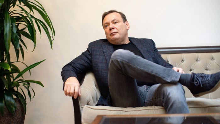 Mikhail Fridman is seated on a sofa