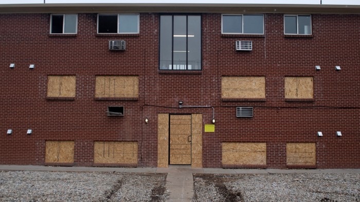 An apartment complex with boarded up windows