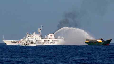 A Chinese coastguard vessel, labeled 5201, uses water cannons against a Philippine resupply vessel, Unaizah