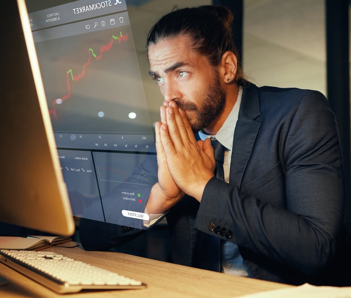 A nervous investor looking at a computer screen.