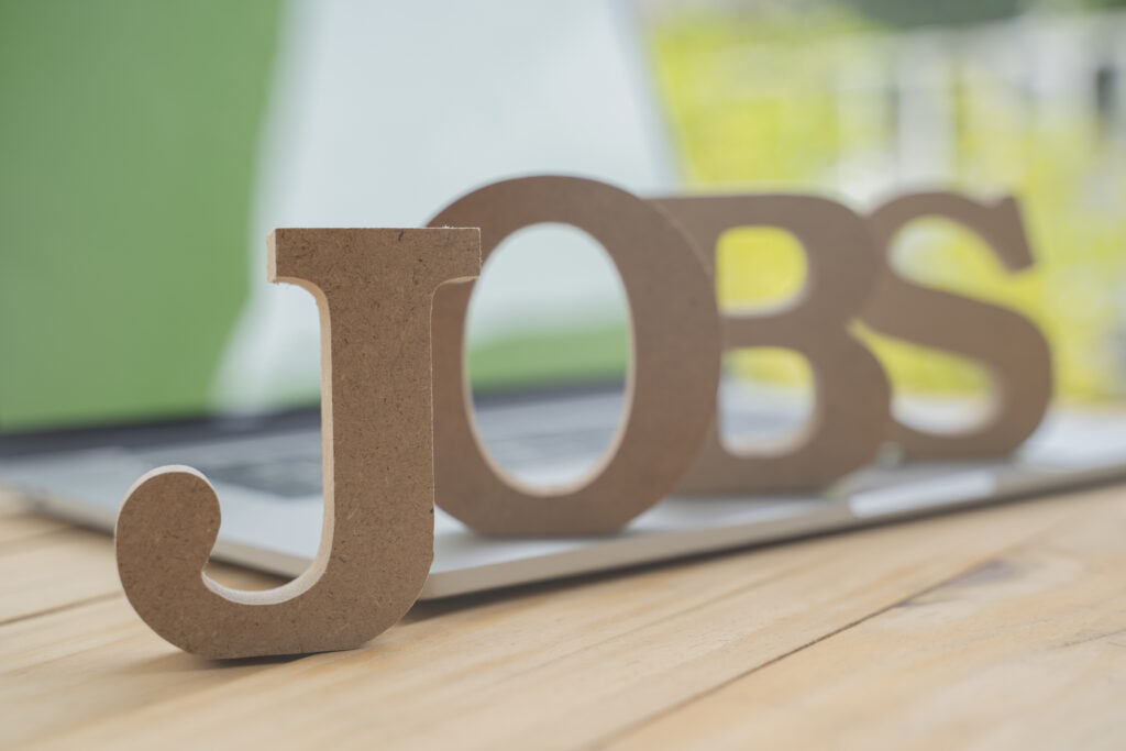 The word &quot;jobs&quot; written in wooden letters that are placed on top of a laptop keyboard