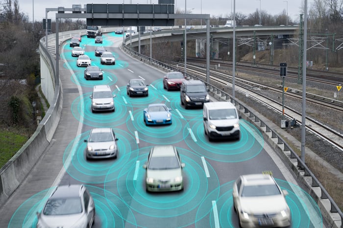 Vehicles on a highway with green sensing circles around them.