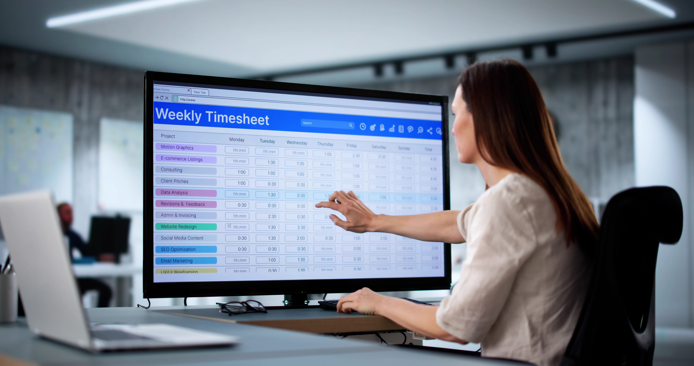 Woman in office signs weekly payroll time sheet for overtime. Business employee records schedule on computer.