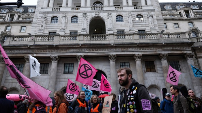 Members and supporters of the environmental movement Extinction Rebellion, hold banners and wave flags as they march in front of the Bank of England, in central London last year