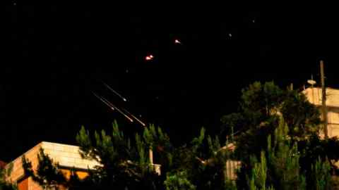 Debris of missiles fired from Iran toward Israel leave trails in the night sky over the Israel-annexed Golan Heights after being intercepted on June 13, 2025