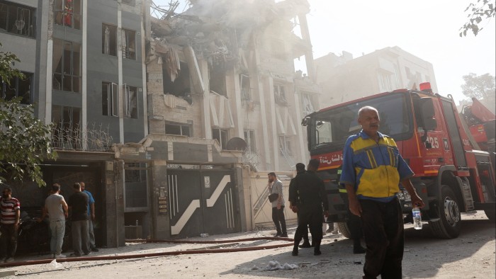 Rescuers work at the scene of a damaged building after Israeli strikes in Tehran