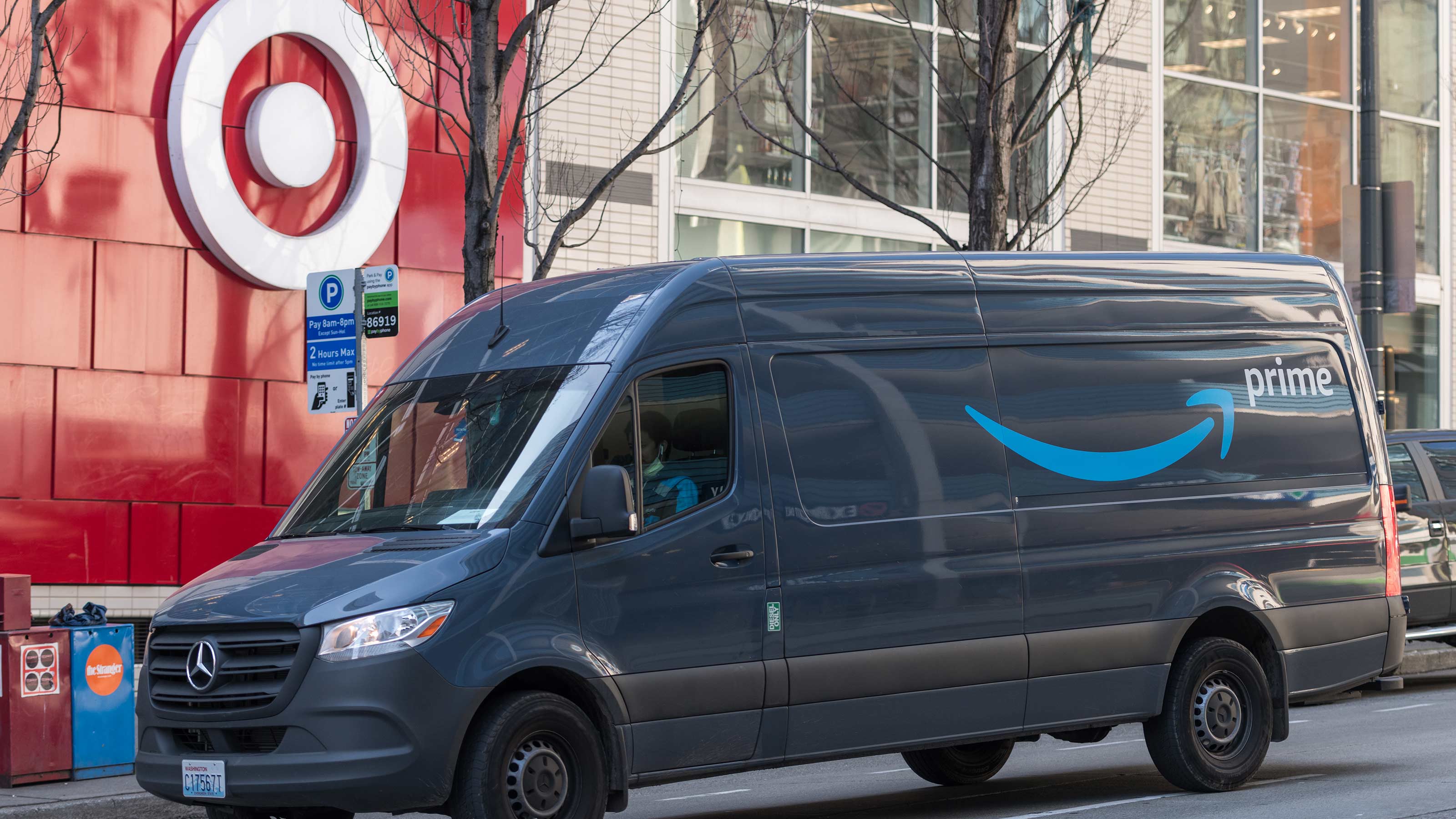 Amazon delivery van rolls past a Target store with the bullseye logo