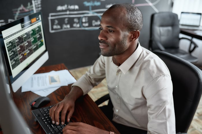 A person sits at a computer looking at investment options.