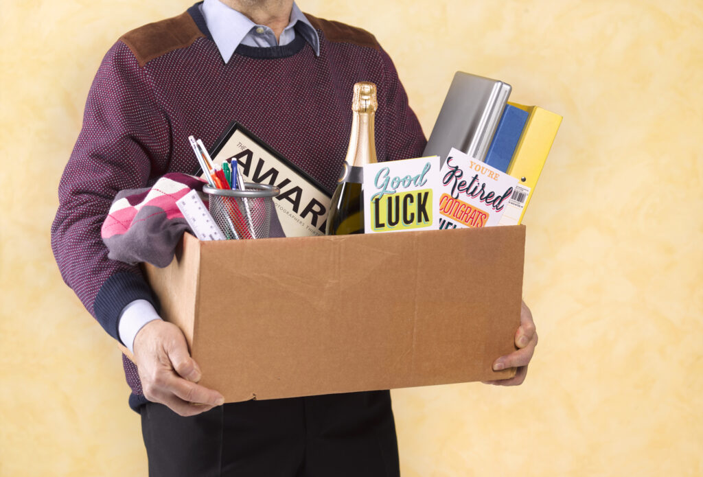 A senior man carrying a box of possessions after retiring