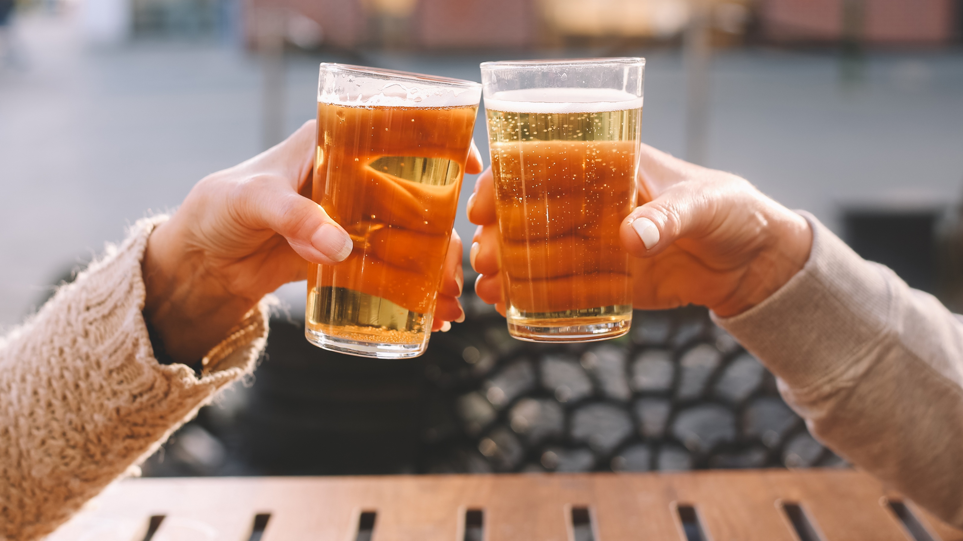 A man and woman toast with their beers.