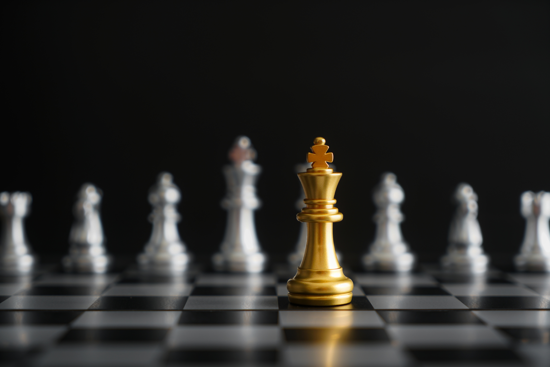 A game of chess is being played with one gold piece