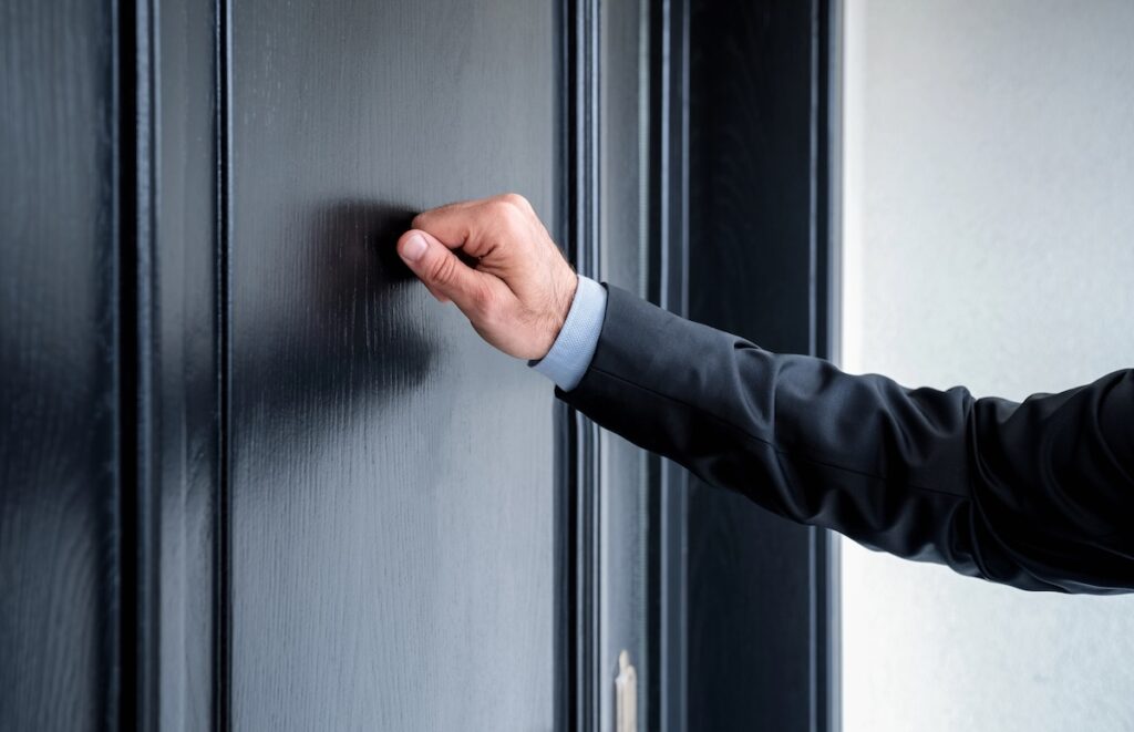 Close up of debt collector knocking on door. | Source: The College Investor