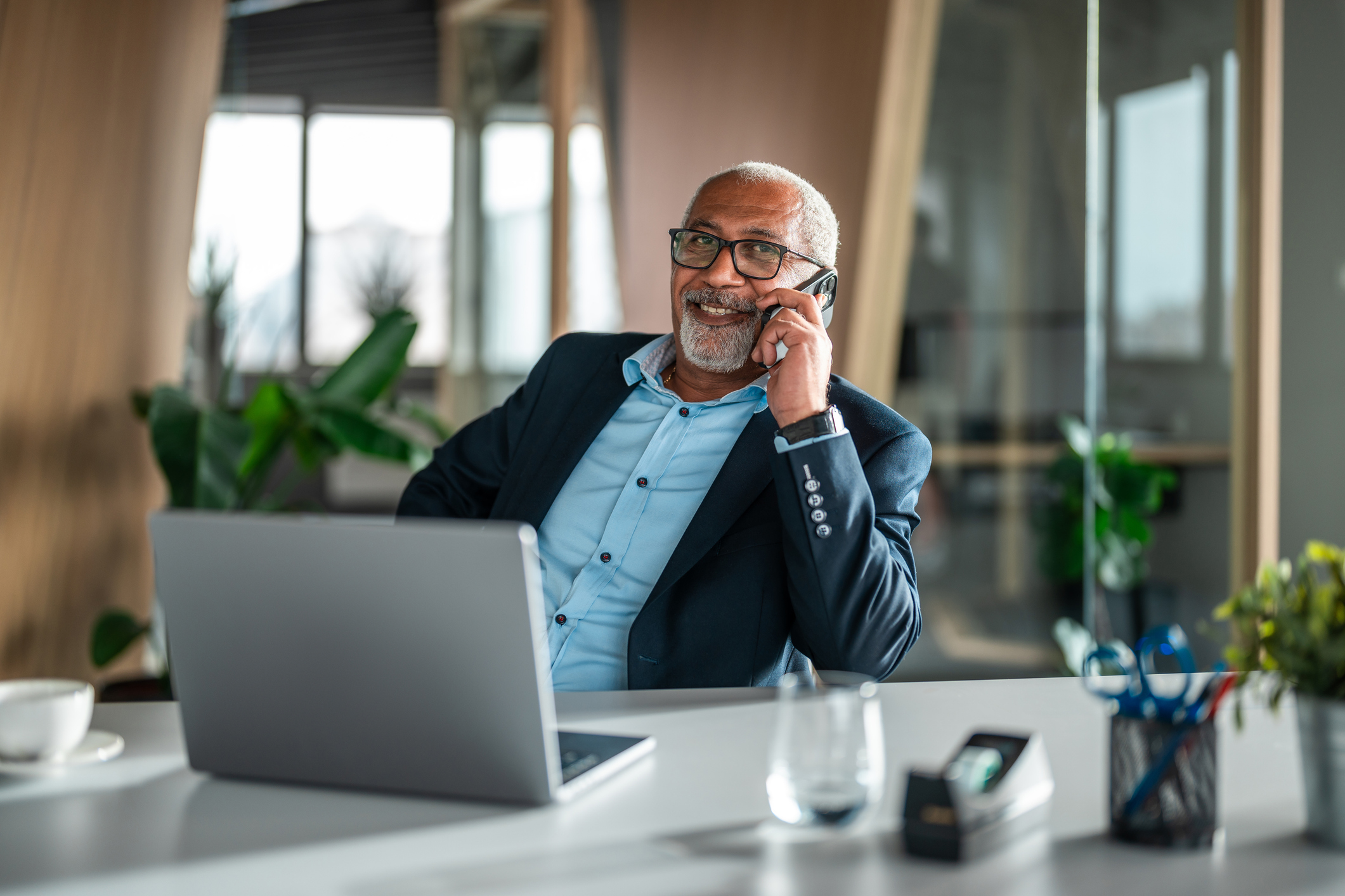 An executive talking on his mobile phone at his desk.