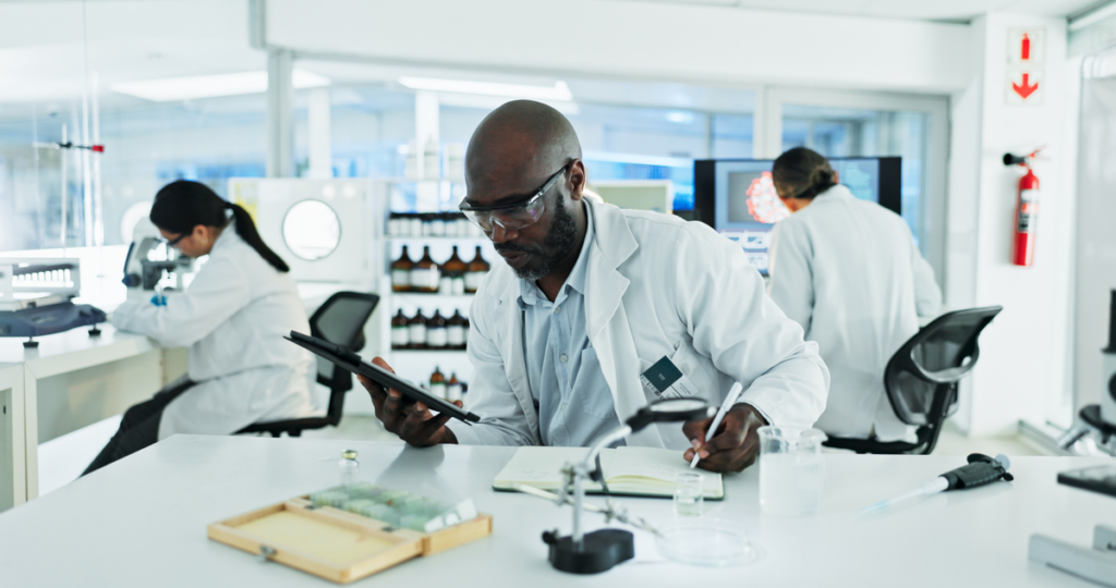 A scientist takes notes while working in a laboratory.