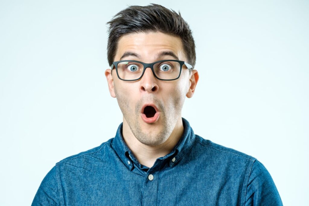 Someone in a blue shirt and glasses has his mouth open, amazed.