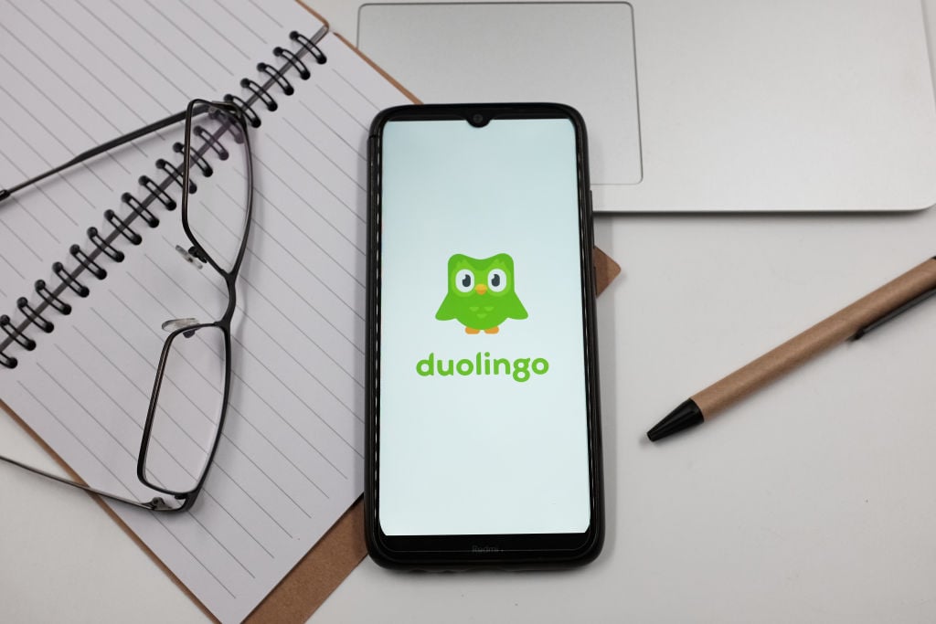 A green Duolingo owl on a smartphone screen.