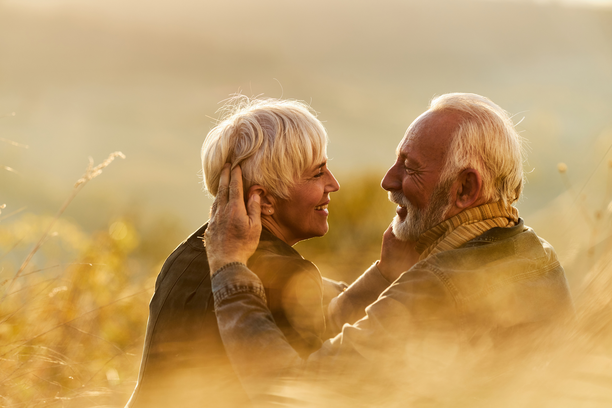 Happy mature couple communicating while enjoying in autumn day on a hill.