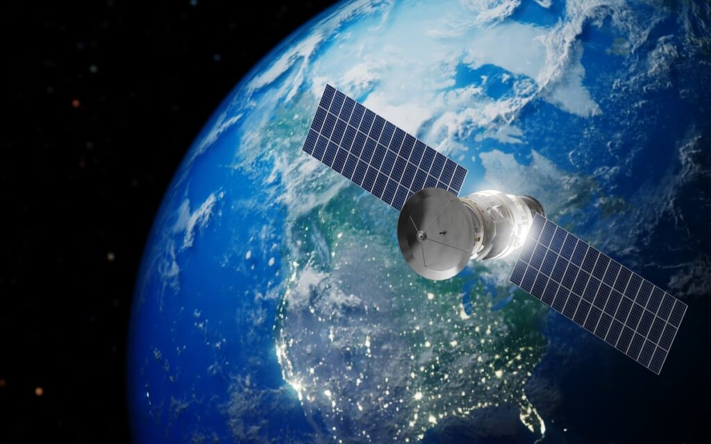 A telecommunications satellite flies in geosynchronous orbit with the Earth.