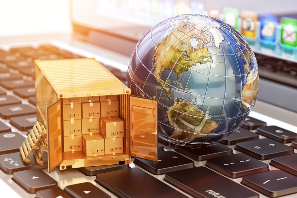 A globe and golden truck loaded with deliveries sitting on top of a computer keyboard.