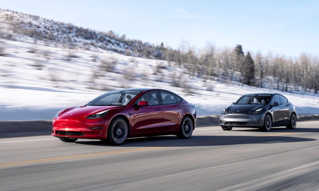 Two teslas in a line driving on road.