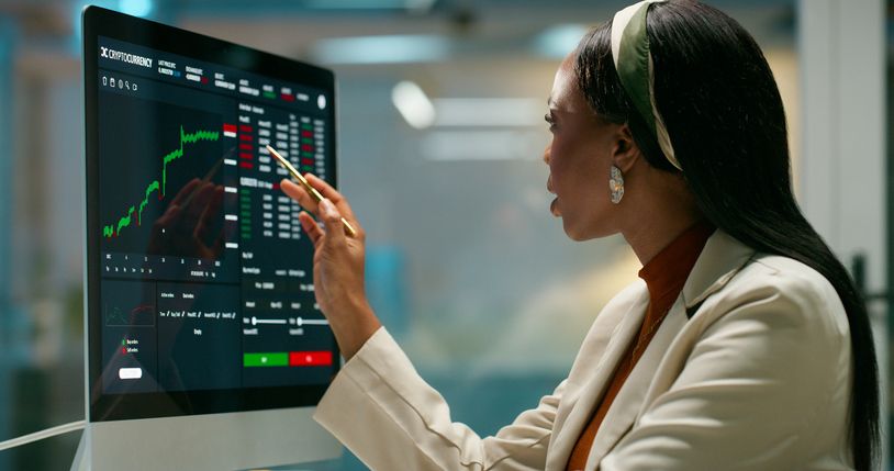 professional woman looking at a screen with stock charts and information