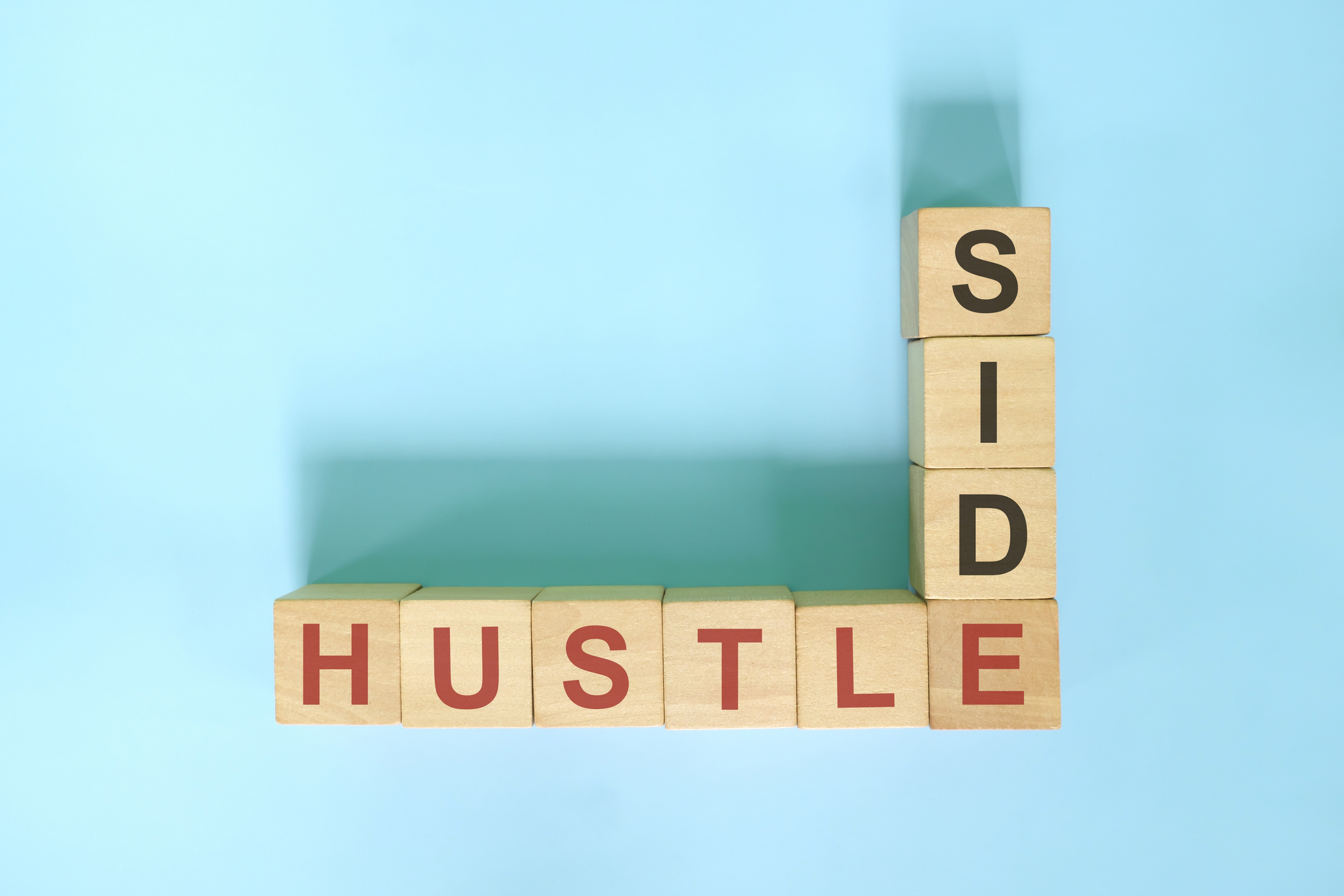 Wooden blocks laid out crossword-style spelling out "side hustle"