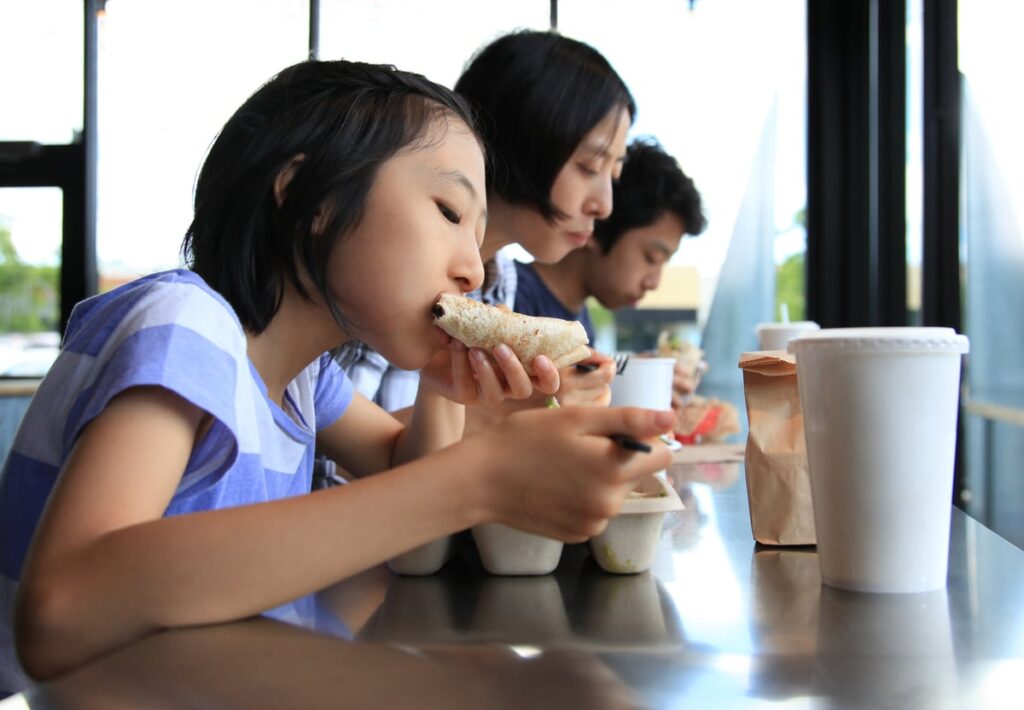 Family of three people eating Tex-Mex food.