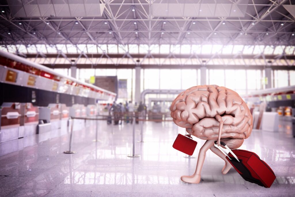 Conceptual 3D illustration of a large human brain with arms and legs, carrying a red suitcase and briefcase while walking through an airport terminal. This visual metaphor represents the potential