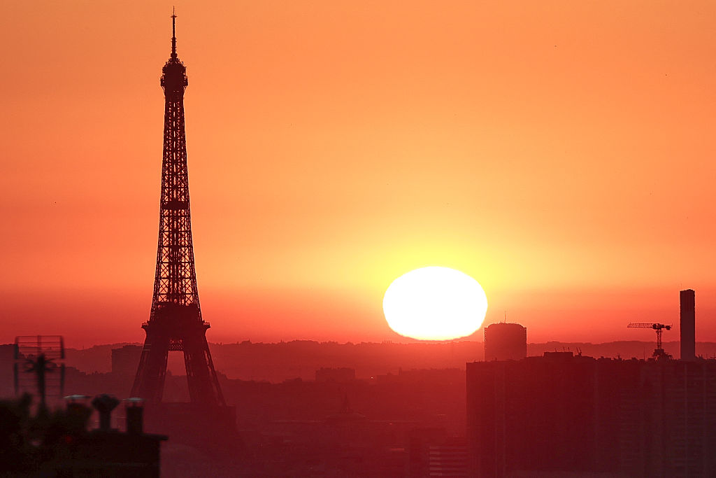 The sun rises by the Eiffel Tower in Paris.