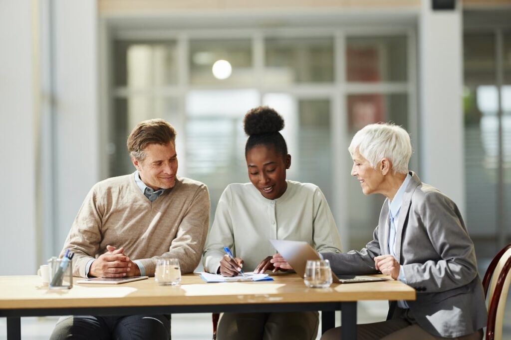 Professional sitting with clients in a meeting.