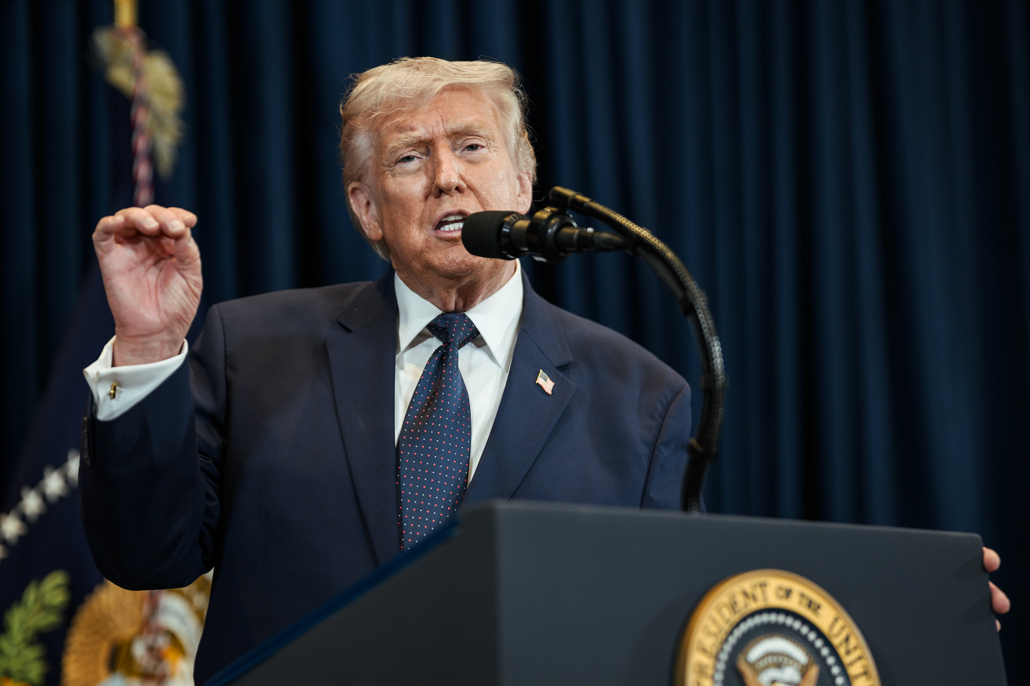 Donald Trump delivering remarks from behind the presidential podium.