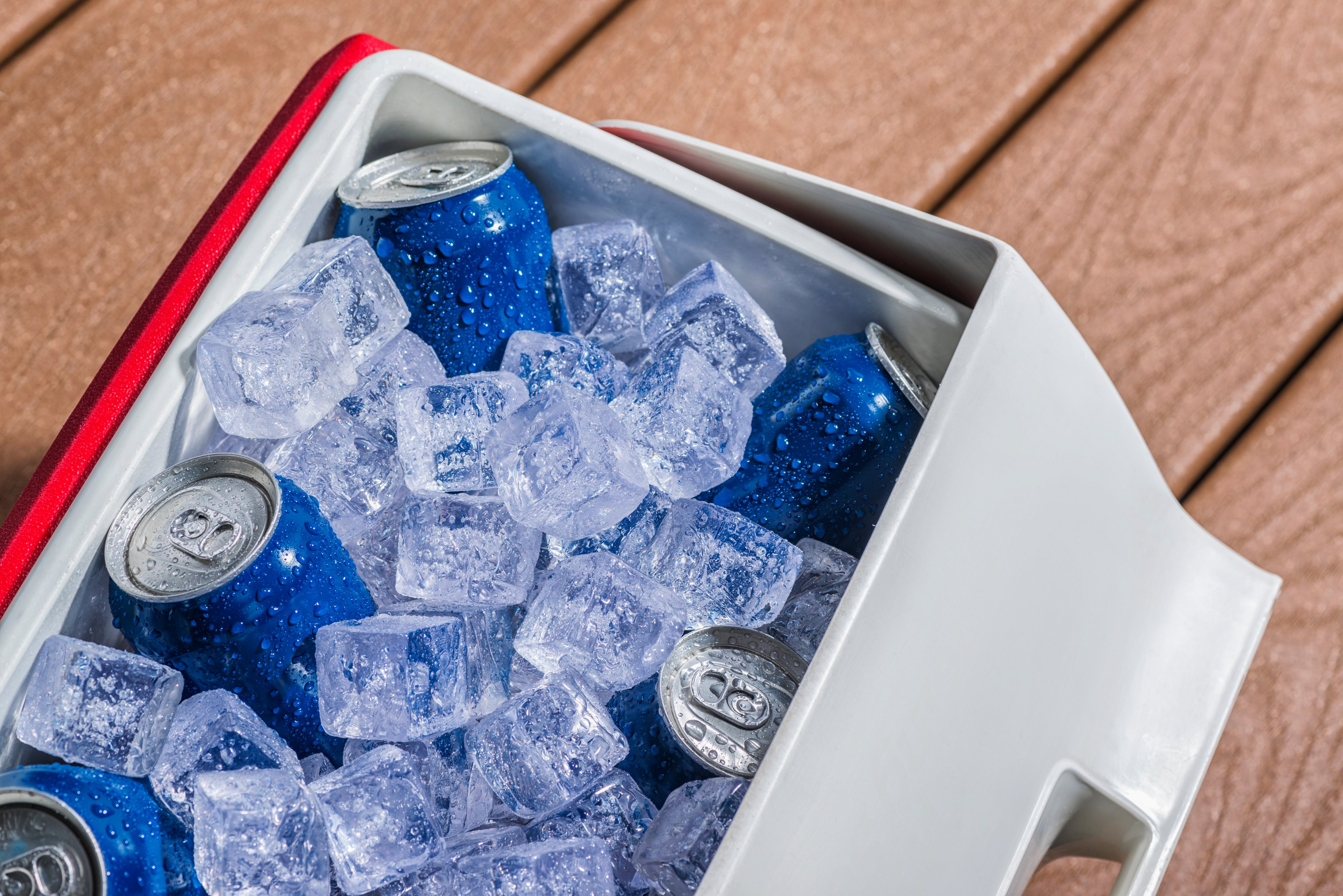 An ice chest sits full of ice and beer.