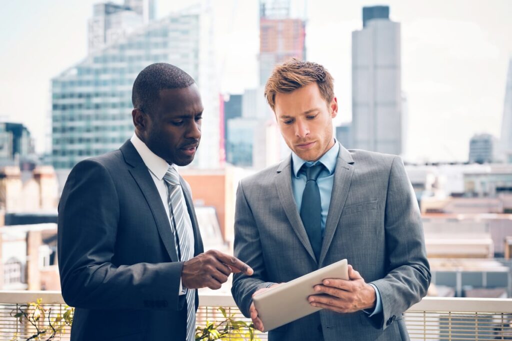 Two investors looking at a tablet.
