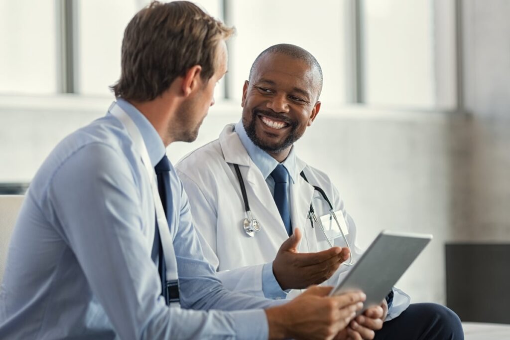 A sales representative discusses something with a doctor.