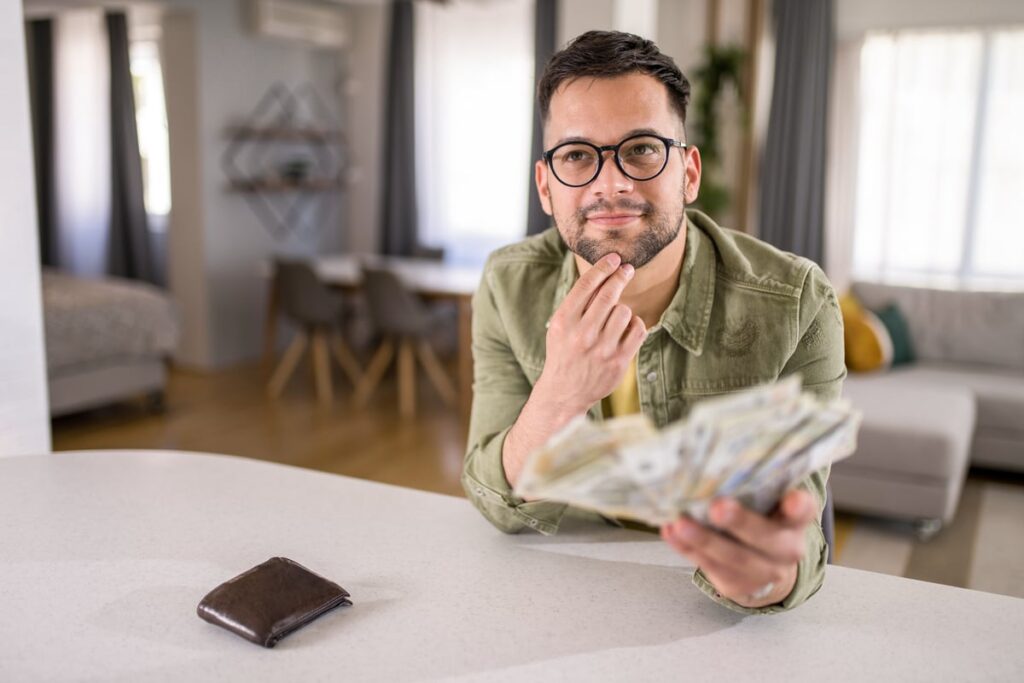 Person thinking and holding money.