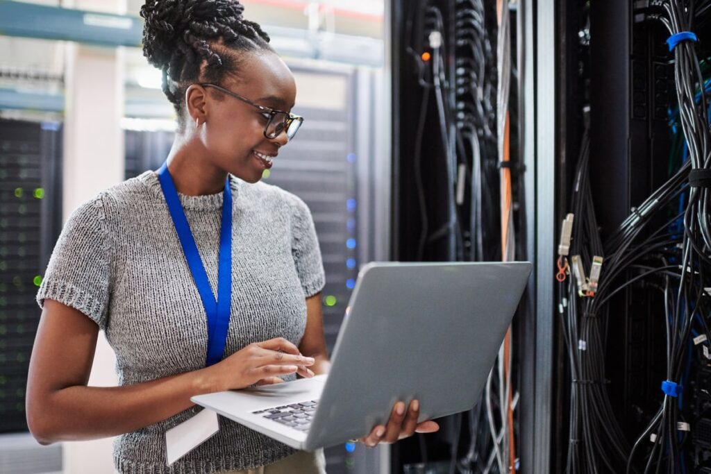 A technician uses a laptop in a data center.