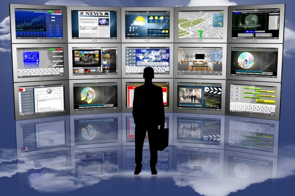 An individual looks at many screens.