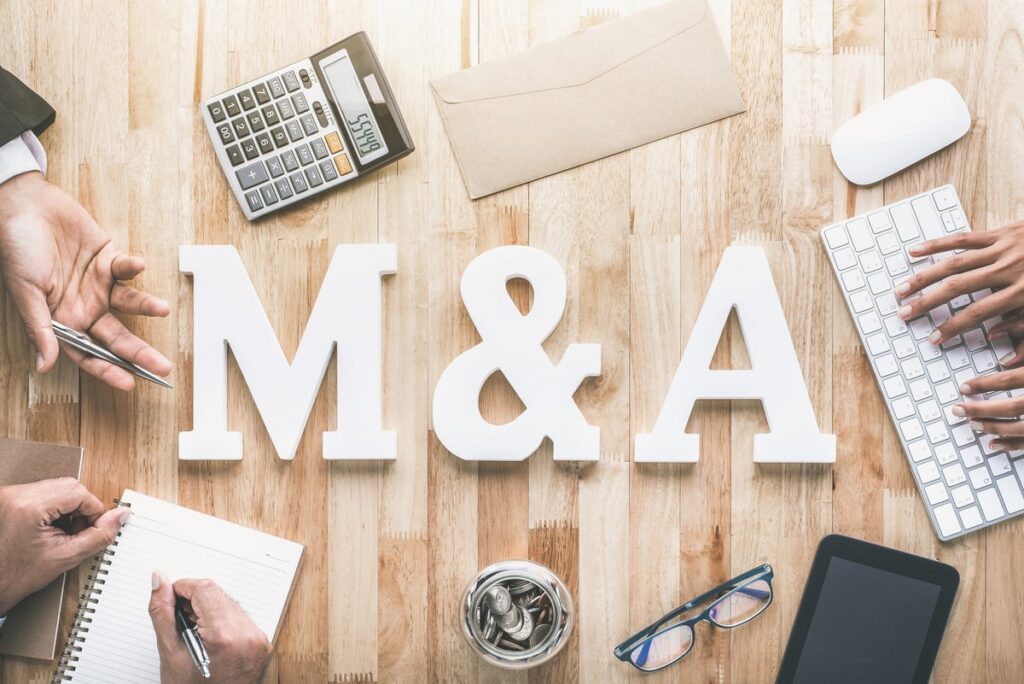 On a wood table, the phrase M&A is written in white letters.