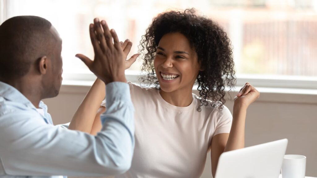 happy investors celebrate with high five.