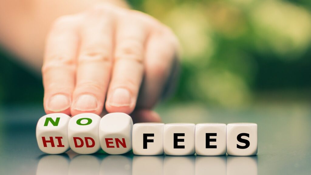 a hand overturns scrabble tiles reading no hidden fees