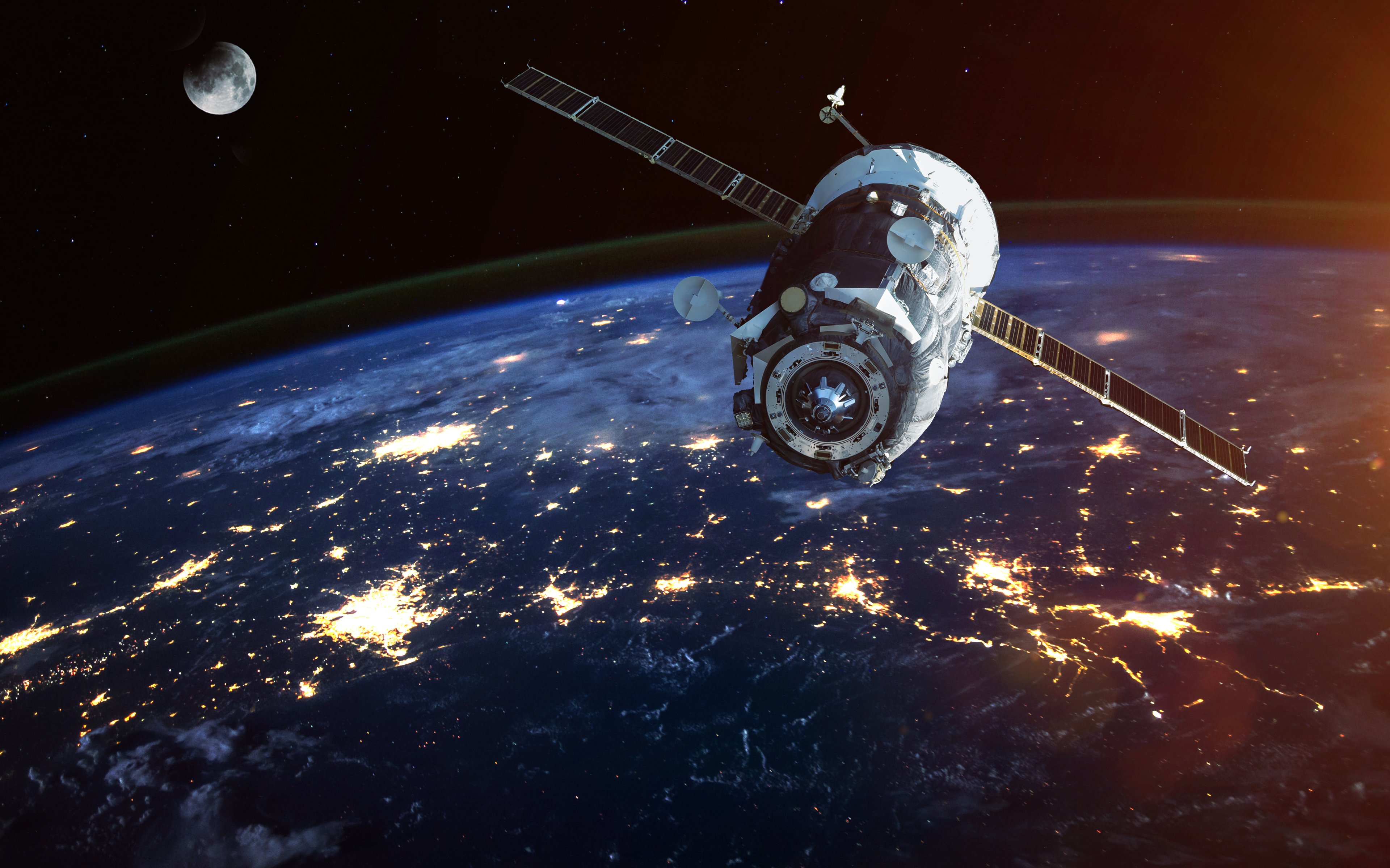 A satellite floats in space at night with the moon in the back. 