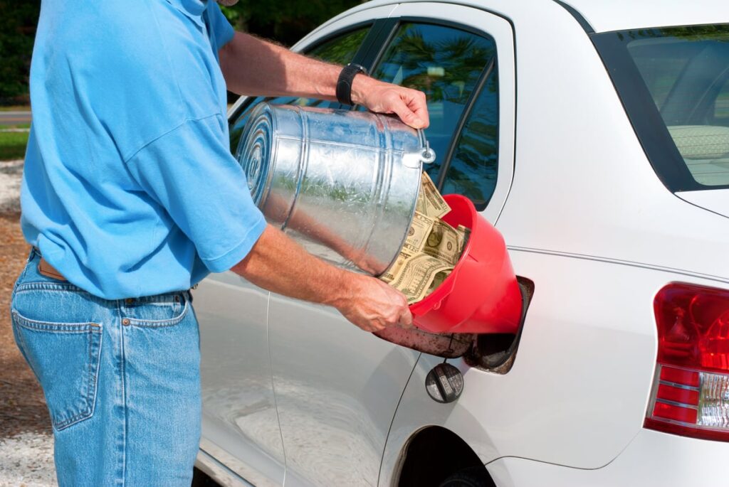 An individual dumps money into his car.