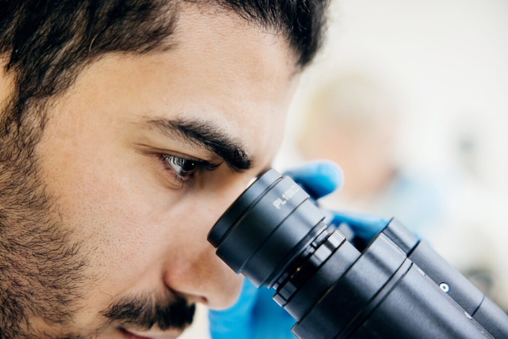 Close Up Of Medical Student Looking Through Microscope