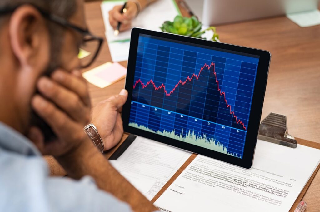 An investor looks at a declining stock chart.