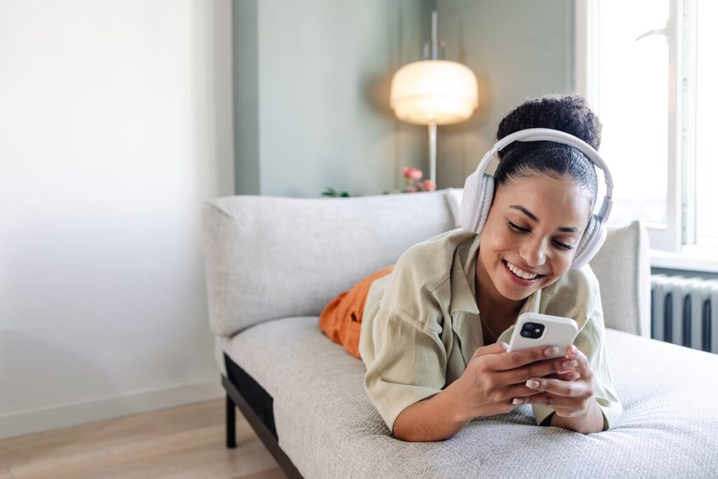 Person reacting joyfully to something on a smartphone.