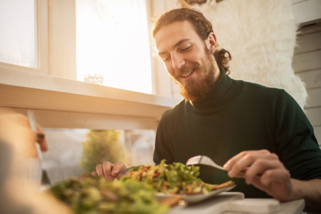 A person is eating a salad in a restaurant.