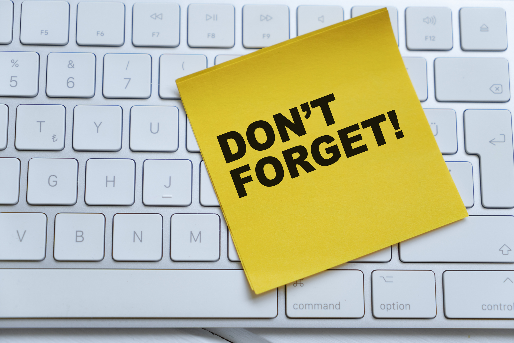 An adhesive note on a computer keyboard - Don&rsquo;t forget